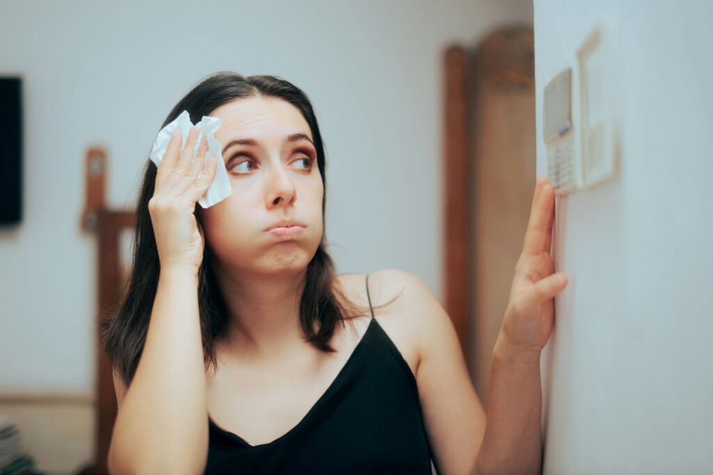 homeowner hot from ac not working checking thermostat