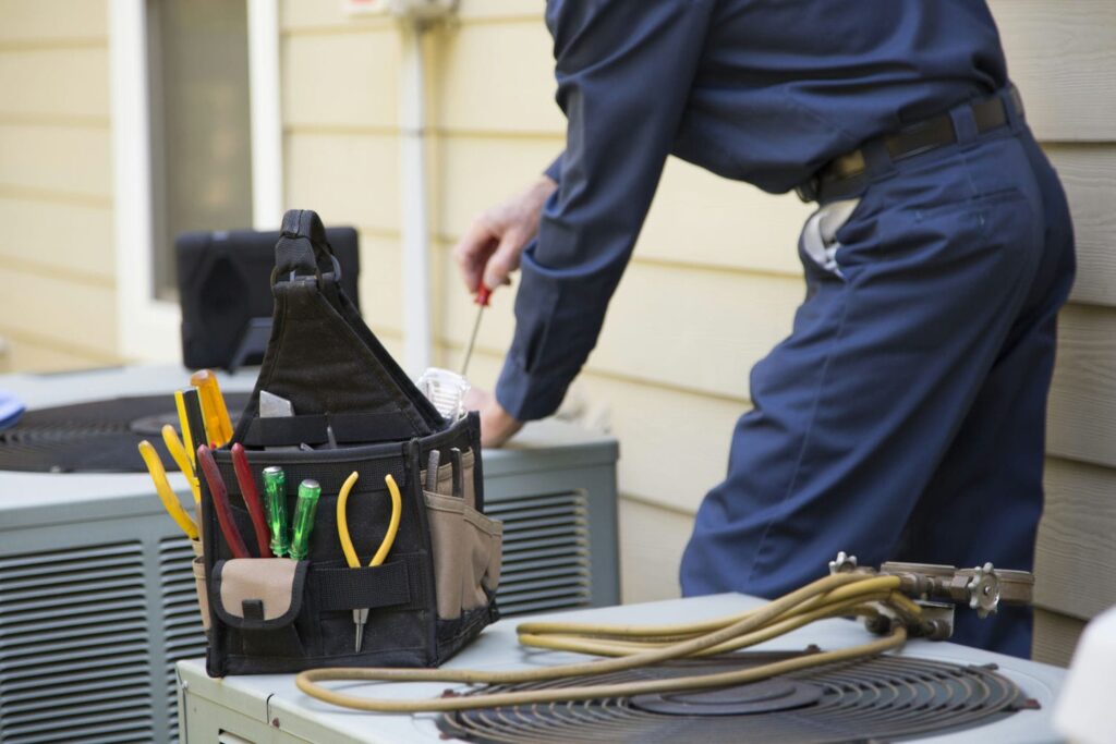 hvac contractor inspecting central AC for leak