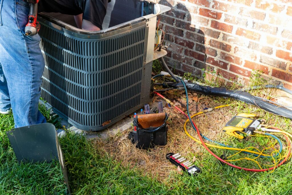 HVAC technician performing maintenance check on central AC unit