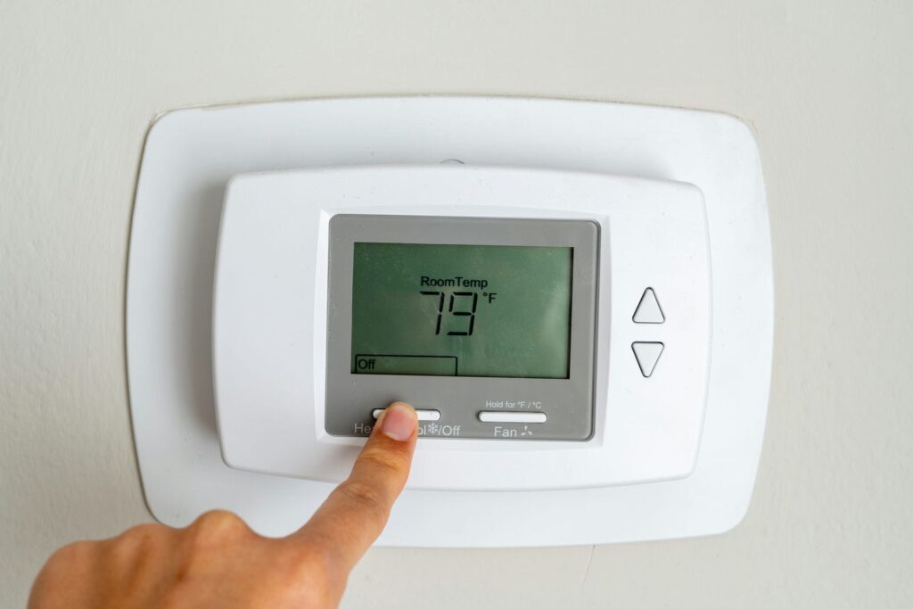 Homeowner turning the thermostat off after an AC breaker trip as a first immediate step