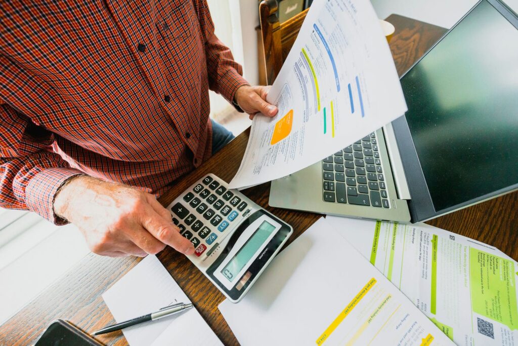 Reviewing energy costs with a calculator and bills, illustrating what a SEER2 efficiency rating means for running costs