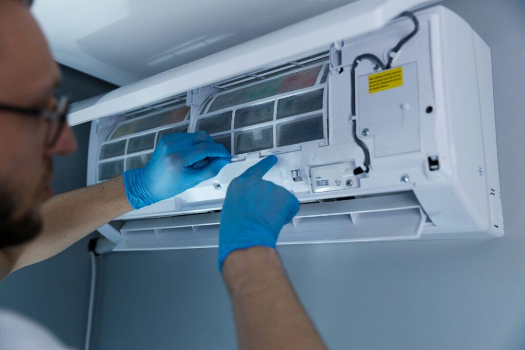 HVAC technician repairing a ductless AC unit